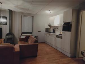 a living room with a couch and a kitchen at vacation home 68 in Tzummarum
