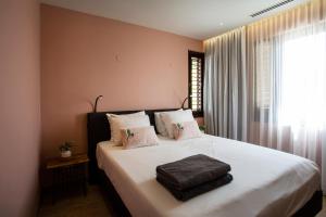 a bedroom with a bed with white sheets and a window at Blue Bay Exclusive in Banda Abou +29 photos