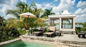 a swimming pool with two chairs and an umbrella at Coqui Coqui Papholchac Coba Residence & Spa in Coba