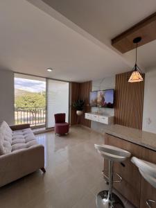 a living room with a couch and a tv at Ruby Suites I Apto en Valledupar I Lujo y Confort I Aire en todas las habitaciones in Valledupar