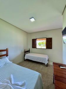 a bedroom with two beds and a window at Pousada Elizium in Montes Claros +88 photos