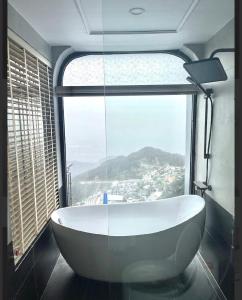 a bath tub in a room with a large window at Time Villa in Tam Ðảo +8 photos