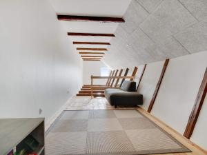 a living room with a chair and a staircase at Two-Story Loft with Large Terrace in Løkken
