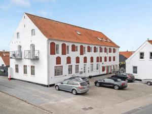 a group of cars parked in front of a white building at Two-Story Loft with Large Terrace in Løkken