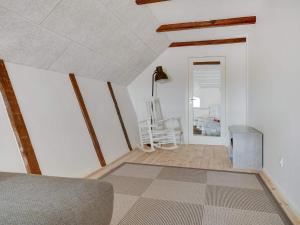 a living room with white walls and wooden beams at Two-Story Loft with Large Terrace in Løkken