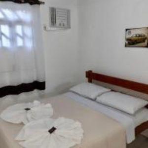 a bedroom with a bed with two towels on it at Pousada Bromelias in Imbassai