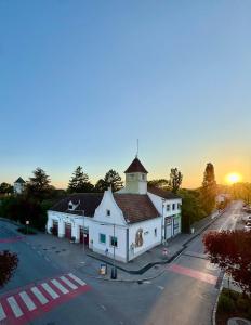 a large white building with a clock tower on a street at Chill & Enjoy in Leopoldsdorf