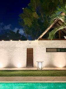 a table in front of a white wall with a door at Aqua Viva in Tulum