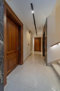 a hallway with a wooden door and a tile floor at Dedinje Luxury Apartment with Spa & Garage in Belgrade