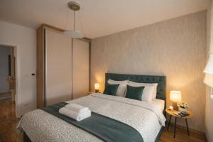 a bedroom with a large bed with two lamps at Apartman River in Bijeljina