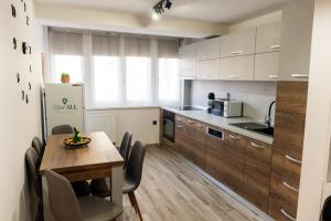 a kitchen with a wooden table and a dining room at Bliss Home 2 by RentALL in Gheorgheni +6 photos