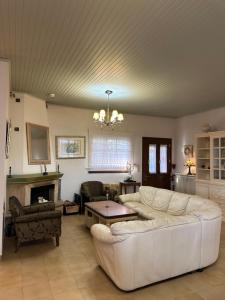 a living room with a white couch and a fireplace at Fokiotrypa Seaside Retreat in Marathias