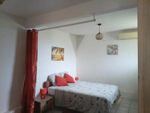 a bedroom with a bed with red pillows on it at Carbet Horizon in Le Carbet