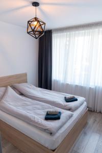 two beds in a bedroom with a large window at Bliss Home 2 by RentALL in Gheorgheni