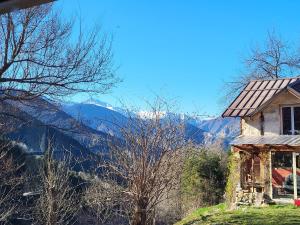 an old house on a hill with mountains in the background at Wild mountains in La Brigue