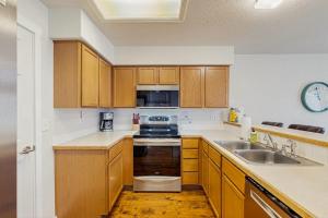 a kitchen with wooden cabinets and a sink at Park View Townhouse in Boise