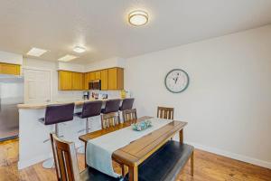 a kitchen with a table and chairs and a clock on the wall at Park View Townhouse in Boise +15 photos