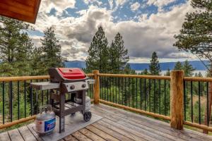 a barbecue grill sitting on a deck on a porch at Cascade Lakeview Log Cabin in Cascade