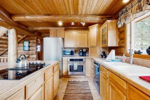 a kitchen with wooden cabinets and a white refrigerator at Cascade Lakeview Log Cabin in Cascade +30 photos