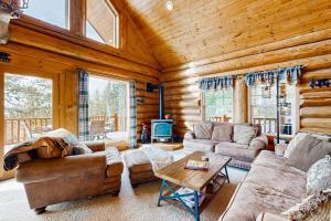 a living room with a couch and a table at Cascade Lakeview Log Cabin in Cascade