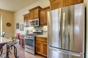 a kitchen with a stainless steel refrigerator and wooden cabinets at Sunglow Townhouse in Boise +26 photos