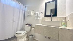 a white bathroom with a toilet and a sink at HOTEL SOÍ BACALAR in Bacalar +40 photos
