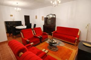 a living room with red furniture and a table at Villa Andy -private yard, swimming pool, panoramic view in Imotski