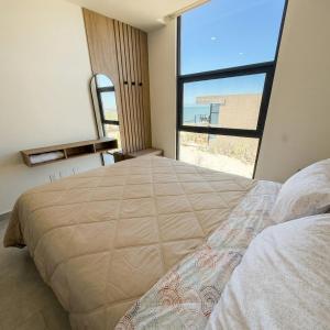 a bedroom with a large bed with a large window at Kocoy Oceanfront condo in Punta Peninsula in Bahía Kino +24 photos