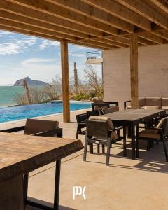 a patio with tables and chairs and a pool at Kocoy Oceanfront condo in Punta Peninsula in Bahía Kino