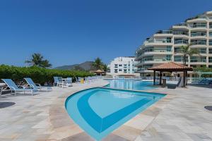 a swimming pool in front of a large building at Apart hotel a Beira Mar na praia do Recreio in Rio de Janeiro