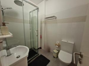 a bathroom with a shower and a toilet and a sink at Arrifana Sea Stay in Aljezur +18 photos