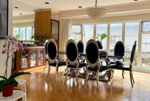 a dining room with chairs and a table and windows at Private Ensuite Room Near YVR Airport Vancouver West in Vancouver