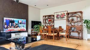 a living room with a dining table and a television at Private Ensuite Room Near YVR Airport Vancouver West in Vancouver