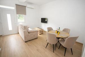 a living room with a table and chairs and a couch at Apartamentos Turísticos El Cholo in Fisterra