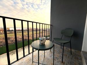 a table and a chair on a balcony with a view at Fly & Stay Otopeni Airport - Self Check-in in Otopeni