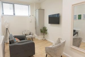 a living room with two chairs and a tv at Derry City Centre 1 & 2 Bedroom Modern Apartments in Derry Londonderry
