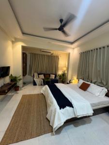 a bedroom with a large bed with a ceiling fan at The Sora Stay in Alibaug