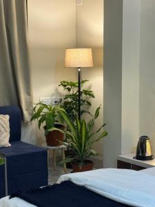 a bedroom with a bed and a lamp and plants at The Sora Stay in Alibaug