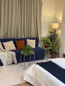 a living room with a blue couch and a table at The Sora Stay in Alibaug
