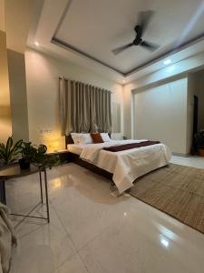 a bedroom with a bed and a ceiling fan at The Sora Stay in Alibaug