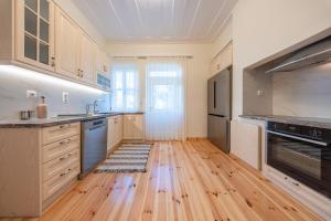 a kitchen with wooden cabinets and a hard wood floor at Eleofilos Old Town in Mytilene
