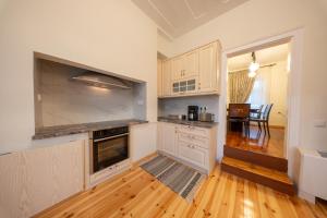 a kitchen with white cabinets and a wooden floor at Eleofilos Old Town in Mytilene +38 photos