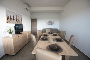 uma sala de jantar com uma longa mesa de madeira e cadeiras em La Casa del Porto Apartment em Civitavecchia