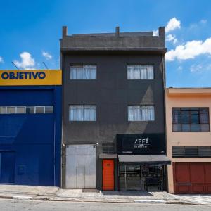 a black building with a orange door in front at Nexus Conceição in São Paulo