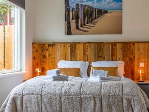 a bedroom with a bed with a wooden wall at Dorpskaemer in Warmenhuizen