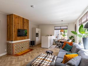 a living room with a couch and a tv at Dorpskaemer in Warmenhuizen