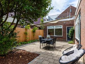 a patio with a table and chairs and a fence at Dorpskaemer in Warmenhuizen