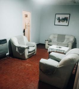 a living room with couches and chairs and a table at Martin House in Chascomús