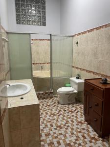 a bathroom with a sink and a toilet and a tub at Alojamiento El Cardenal in Iquitos +31 photos