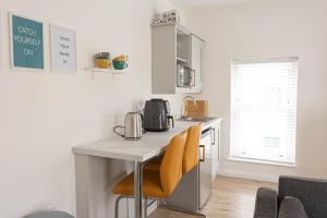 a kitchen with a table and two yellow chairs at Derry City Centre 1 & 2 Bedroom Modern Apartments in Derry Londonderry
